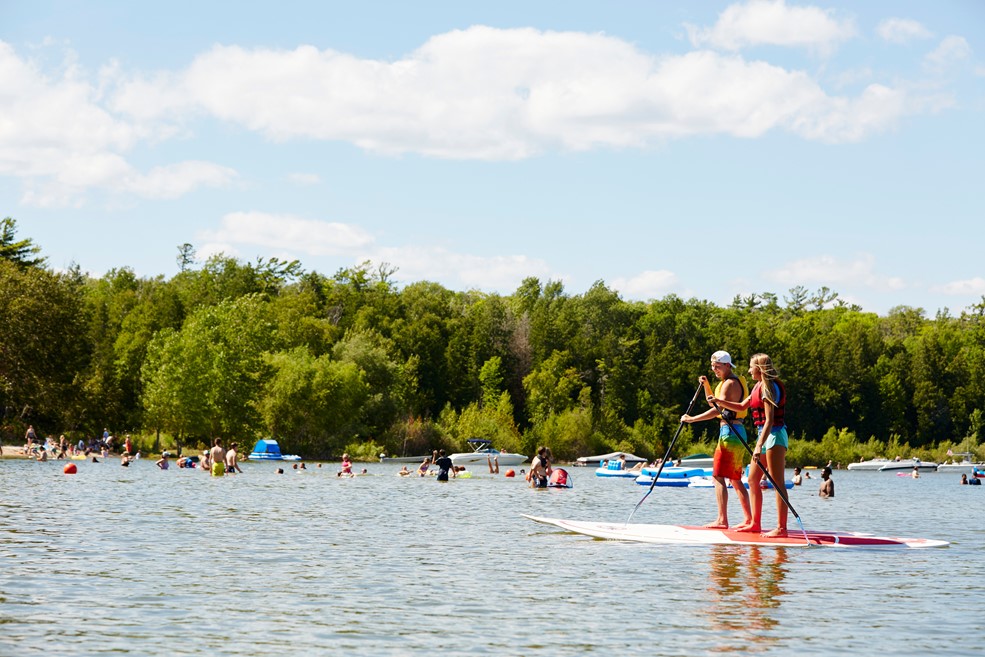 Two people standup paddle boarding on the lake.