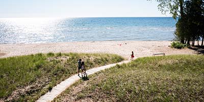 People walking on a boardwalk to the beach