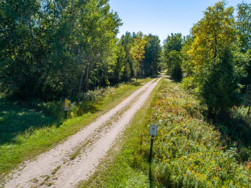 A view down the lush green and tree-lined Ahnapee Trail.