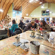 Groups of friends paint and make art at a hands-on arts studio.