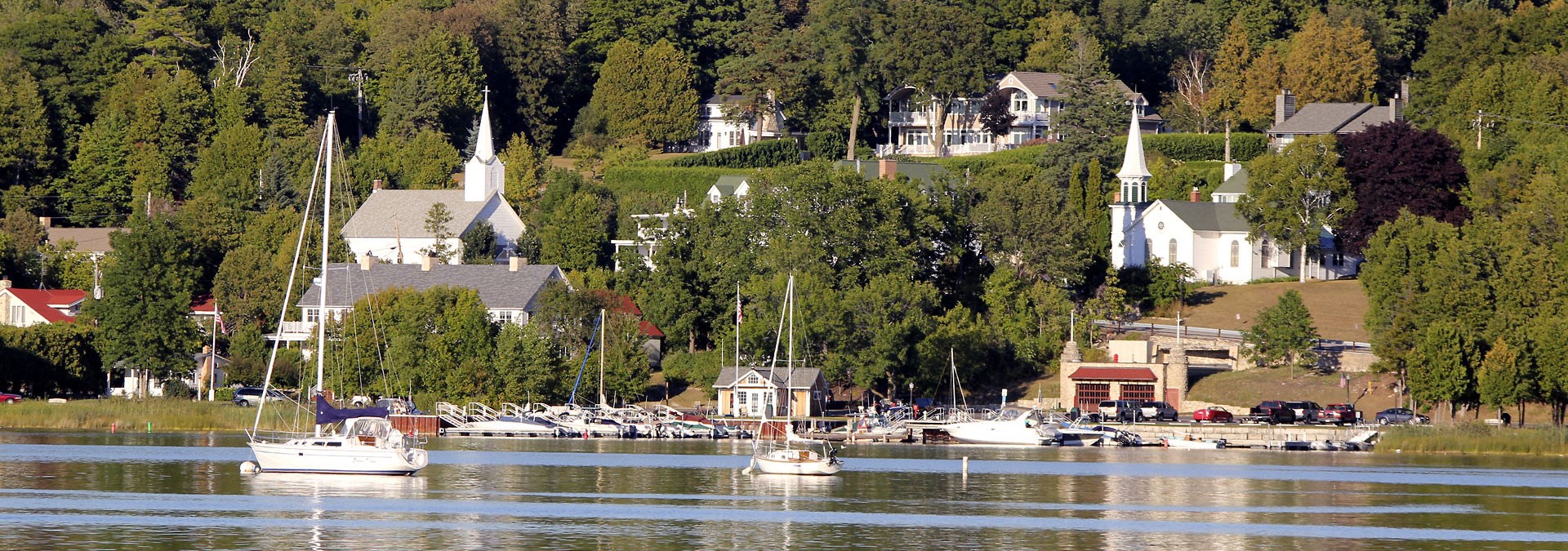 Sailboats in front of a town on the lake.