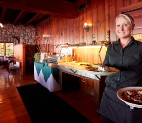 Woman holding plates of food in a supper club.