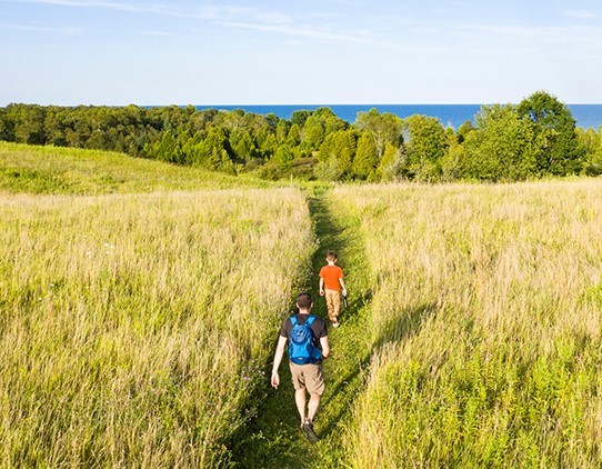 Aerial view of two hikers at Cave Point.