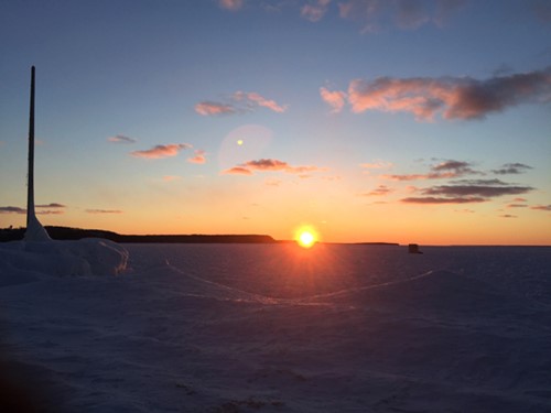 A brilliant winter sunset over Lake Michigan with blues, oranges, and pinks.