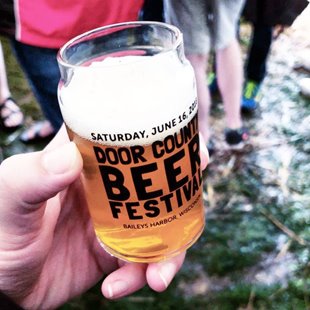 Closeup of someone holding a glass of beer.