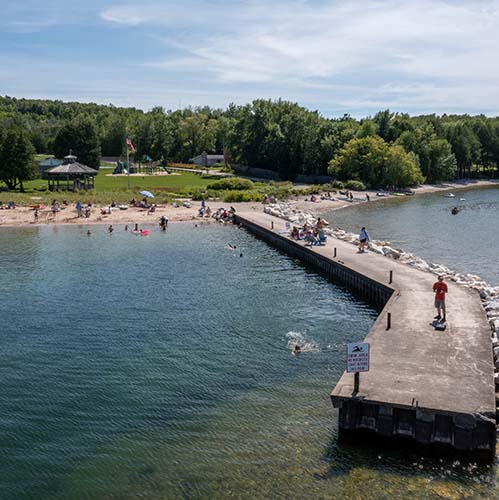 People enjoying the beach, water and pier.