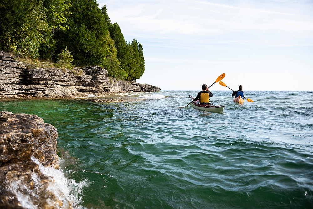 Two people kayaking along the lakefront