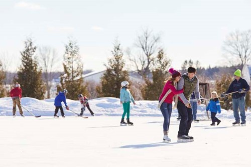 A happy couple ice skating on a frozen pond.