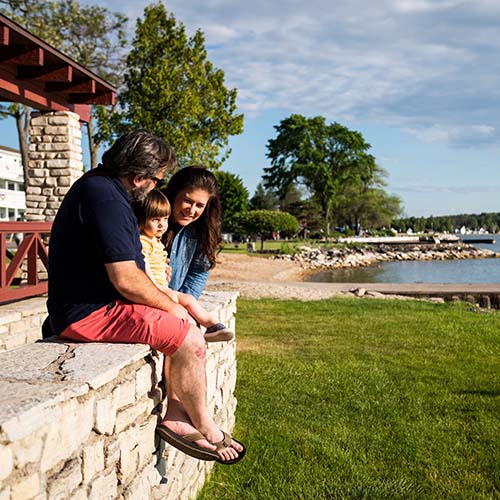 A family sitting on a wall ledge