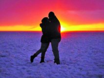 The silhouette of a couple hugging in the snow.