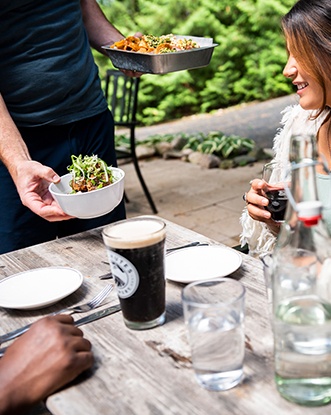 A server drops off entrees to a happy young couple.