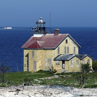 A lighthouse on a hill overlooking the lake.