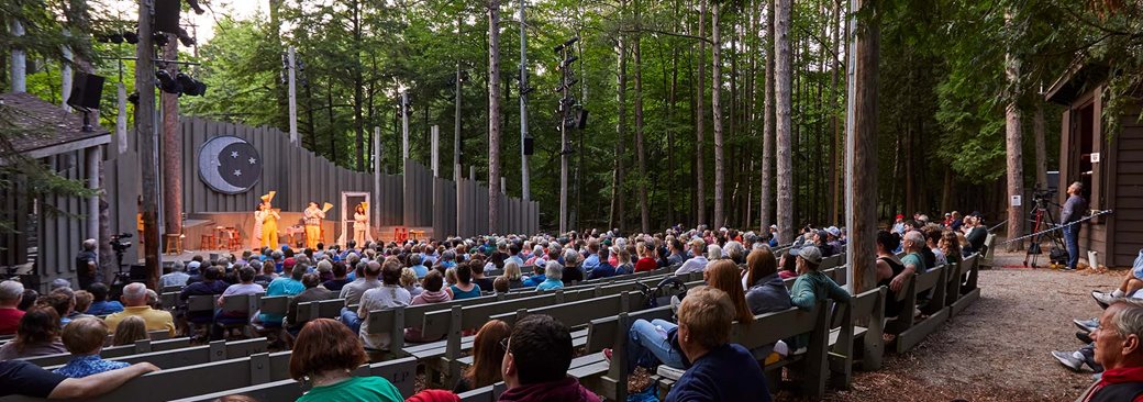 People outside watching a theater performance