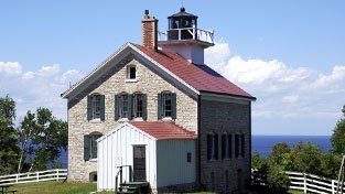 A lighthouse on a hill overlooking the lake.