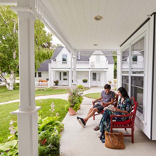 A couple sitting in chairs outside of a building