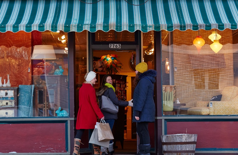 Three women entering a shop.