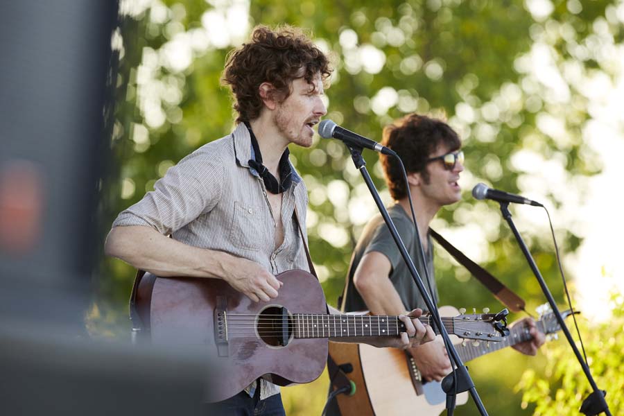 A rock band plays an outdoor show.