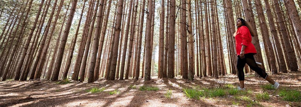 A woman walking through the woods.