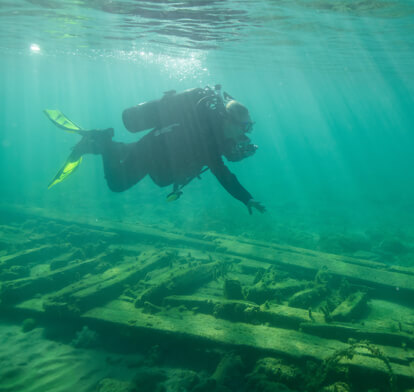 Scuba diver exploring around a shipwreck.