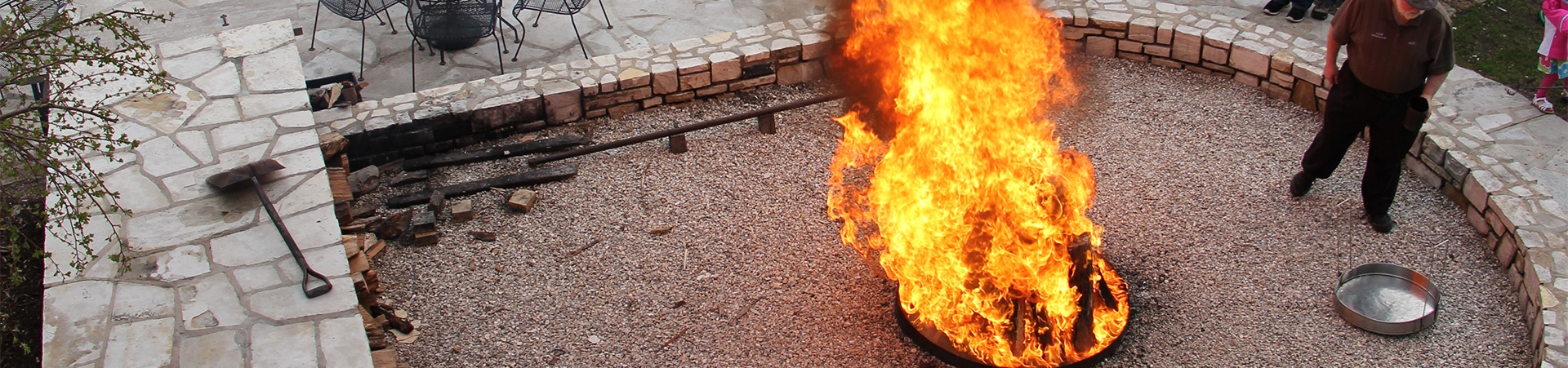 Man standing next to a large fire at a fish boil.