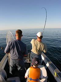 Two men fishing off of their boat.