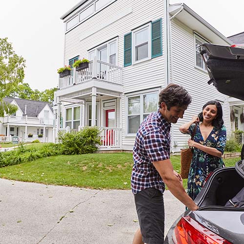 A couple unloading things from the trunk of a car