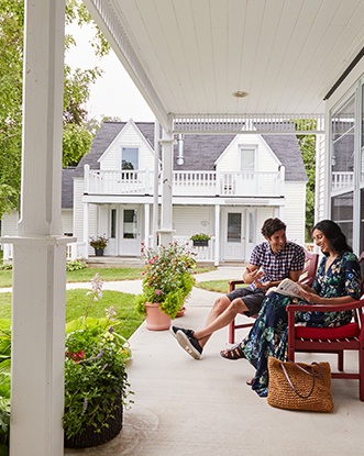 A couple relaxes on the porch at a serene inn.