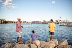 A family fishing off of the rocks.