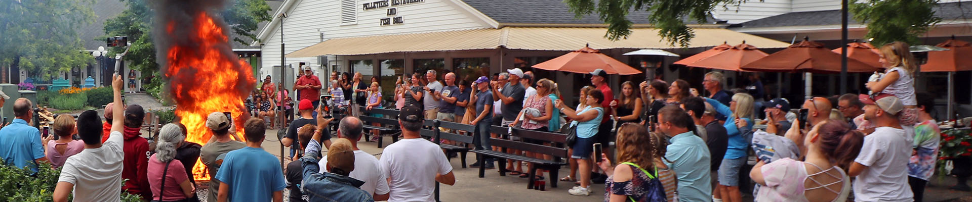 A crowd gathers around a large bonfire during a friendly group dining experience in Door County.