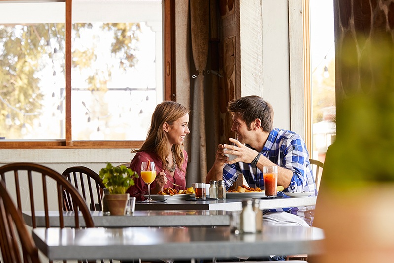 A couples dine at brunch with mimosa and bloody marys