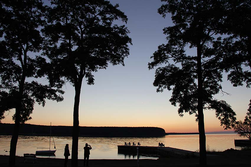 Eagle Harbor during a summer sunset with purple and orange hues.