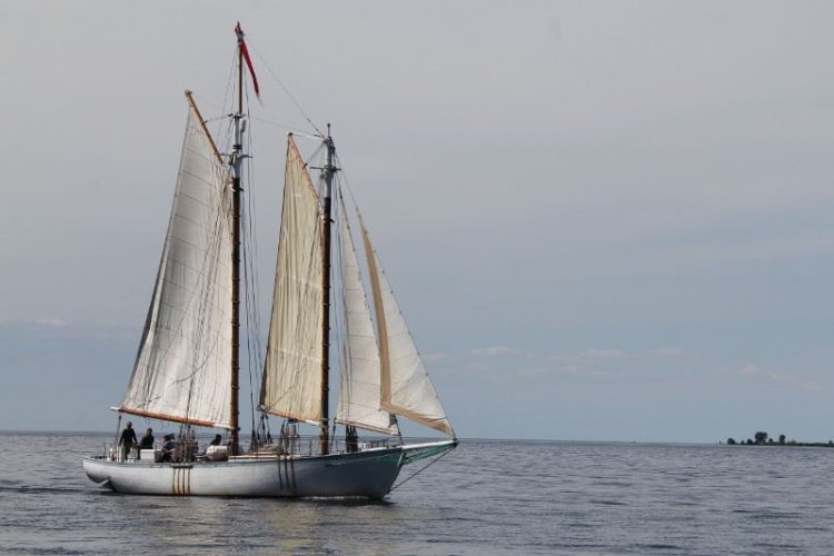 A large sailboat out on the lake.