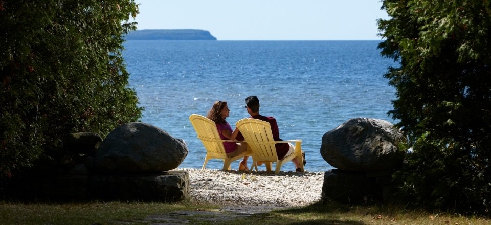 Couple sitting in chairs at the lakefront