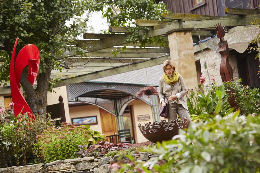 A woman browses an outdoor sculpture gallery.