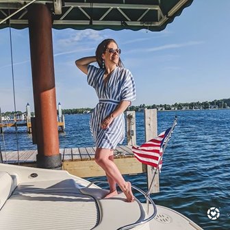 A woman posing for a picture on the back of a boat.